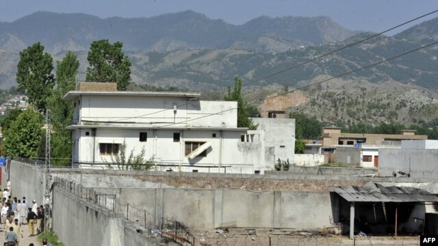 Police, reporters, and local residents gather outside Osama bin Laden's compound in Abbottabad following his death.