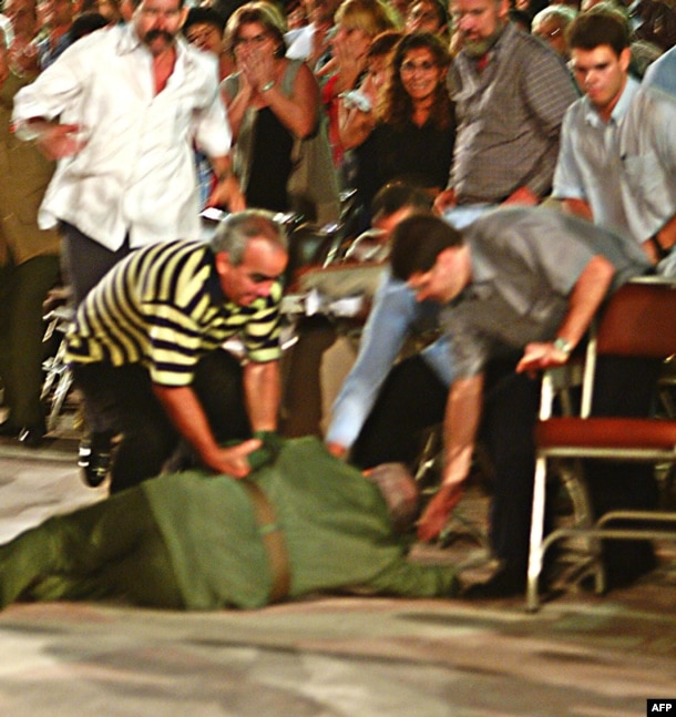 Castro (center) is helped by his bodyguards after he fell over at the end of a speech following a graduation ceremony in central Cuba in October 2004.