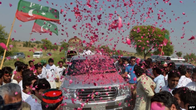 Pakistanis welcome the convoy of cricket star turned politician Imran Khan on his rally toward the tribal areas in Mianwali on October 6.