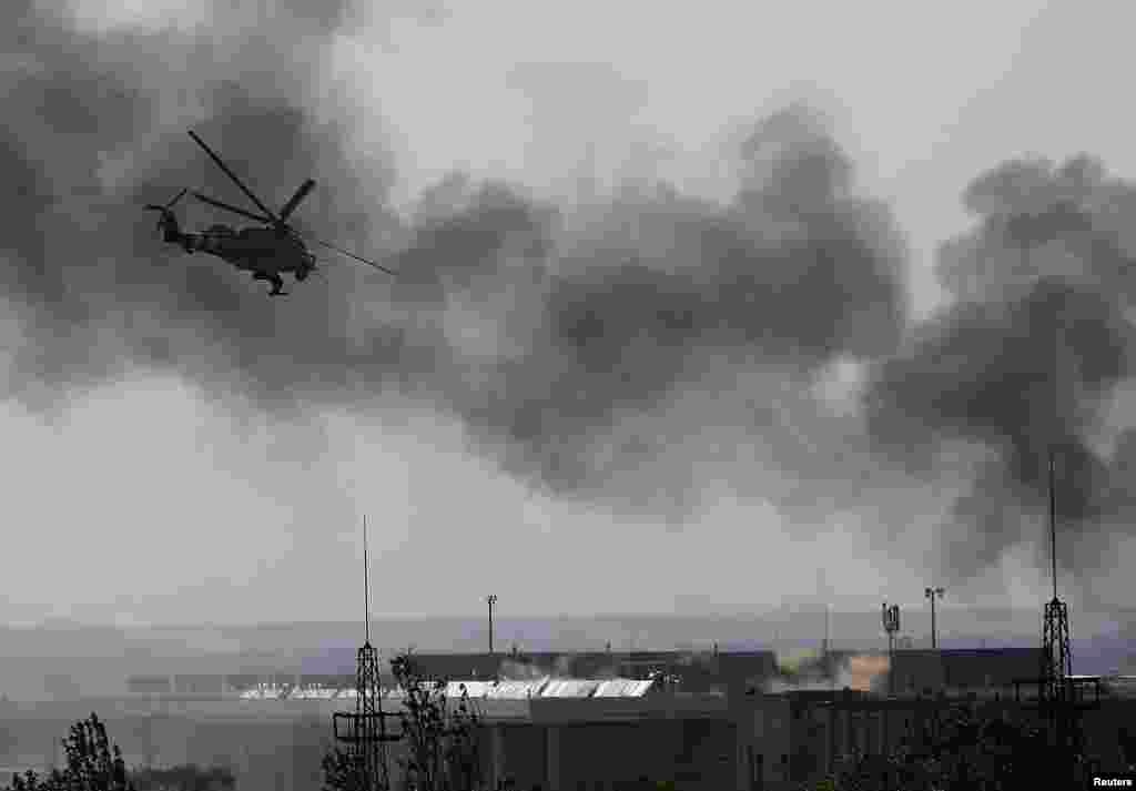 A Ukrainian Mi-24 helicopter gunship fires its cannons at rebels at the main terminal building of Donetsk's international airport on May 26.