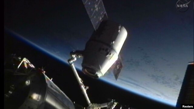 The SpaceX Dragon craft is seen during its maiden voyage to the International Space Station (attached) as it was prepared for its return to Earth in June 2012.