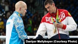 Russian boxer Yevgeny Tishchenko (right) shakes hands with Kazakhstan's Vasly Levit after their controversial heavyweight bout at the Rio Olympics.