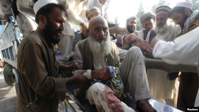 Men assist fellow Afghans injured in a bomb blast as they arrive at a hospital in Jalalabad in September.