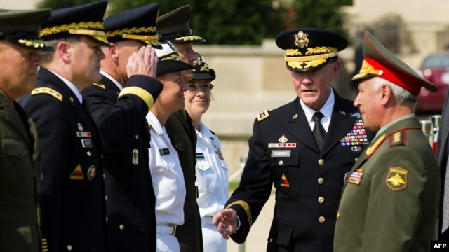 Russian General of the Army Nikolai Makarov (right) is introduced by U.S. Chief of Staff General Patrick Dempsey (center) during a full honor cordon at the Pentagon in Washington on July 12.