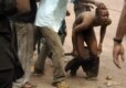 A heckler being beaten at a rally for opposition candidate for the Congolese presidency, Oscar Kashala (AFP)