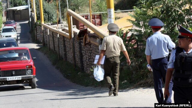 Оқиға маңындағы полицейлер мен әскери адам. Алматы облысы, Қарасай ауданы, 17 тамыз 2012 жыл.