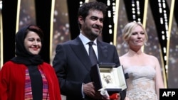 Iranian actor Shahab Hosseini (center) poses with Cannes jury members Iranian producer Katayoon Shahabi (left) and American actress Kirsten Dunst after being gvien the Best Actor prize during the closing ceremony of the 69th Cannes Film Festival.