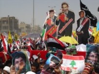 Cutouts of the U.S. president and the British and Israeli prime ministers loom above scores of thousands of marchers in Baghdad (RFE/RL)