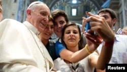 Pope Francis poses with young people during a meeting at the Vatican earlier this year.