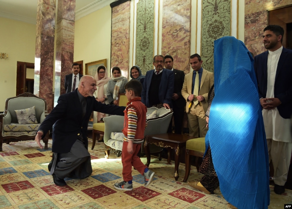 Afghan President Ashraf Ghani (left) greets the son (center) of refugee Sharbat Gula (second right) at the Presidential Palace in Kabul following her deportation from Pakistan on November 9. (AFP/Shah Marai)