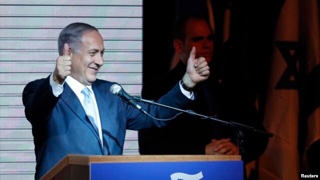 Israeli Prime Minister Benjamin Netanyahu gestures to supporters at party headquarters in Tel Aviv early on March 18.