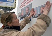 A Belarusian activist puts up a poster of opposition presidential candidate Alyaksandr Milinkevich (epa)
