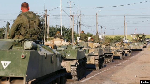 Russian military personnel sit atop armored vehicles outside Kamensk-Shakhtinsky in Russia's Rostov Region, near the border with Ukraine, on August 15.
