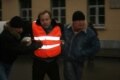 A man wearing a vest identifying him as a member of the press is detained in the Moscow fracas