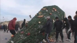 Protesters kick a fallen holiday tree in Zhanaozen on December 16.