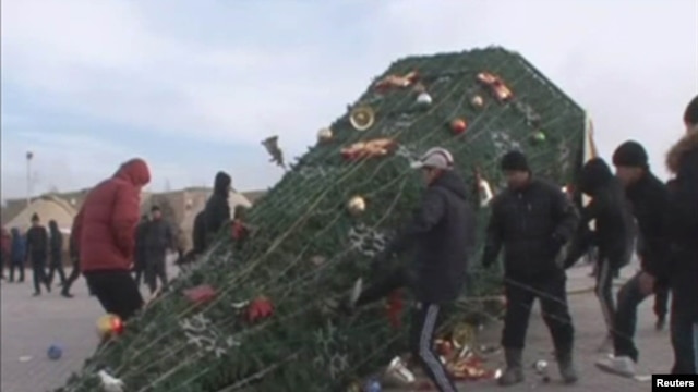Protesters kick a fallen holiday tree in Zhanaozen on December 16.