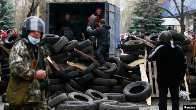Pro-Russian protesters unload tires to form barricades at the police headquarters in Slovyansk.