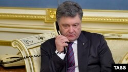 Ukrainian President Petro Poroshenko talks to Nadia Savchenko by phone at the presidential office in Kyiv on April 19.