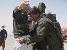 Afghanistan - An Afghan Policeman frisks a man at a checkpoint in troubled Helmand province, 07Mar2007