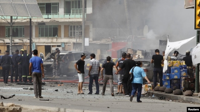 Iraqis gather at the site of a bomb attack in central Baghdad on July 31.