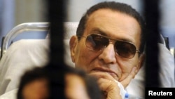 Former Egyptian President Hosni Mubarak sits inside a cage during a court hearing earlier this year.