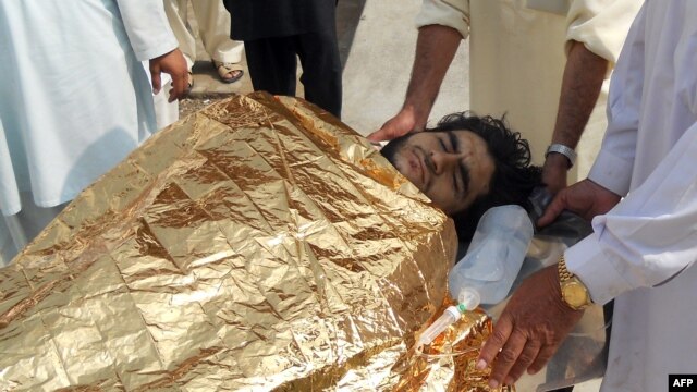 Men carry a bombing victim into a hospital following an attack on the home of militant commander Mullah Nabi Hanafi in northwestern Pakistan.