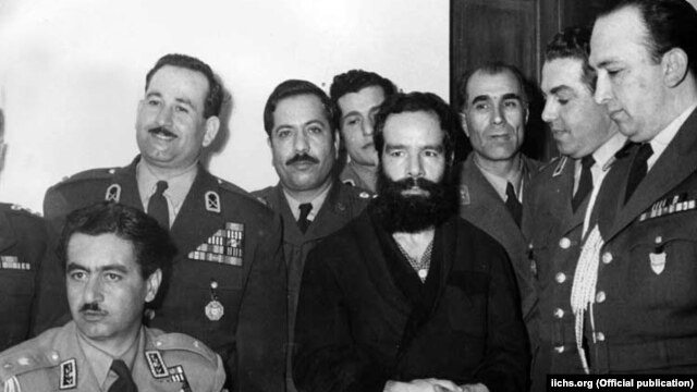 حسین فاطمی (در میانه تصویر) اندکی پس از بازداشت توسط نیروهای تیمور بختیار (نشسته، چپ) فرماندار نظامی وقت تهران