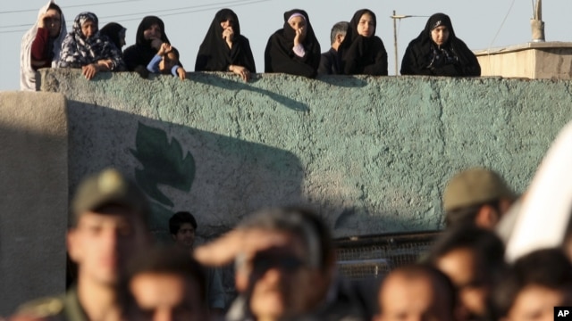 Iranians watch the public execution of a convicted man in the city of Qazvin in May 2011.