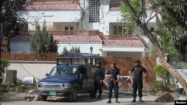Policemen stand guard outside the house where Osama bin Laden's family is believed to have lived in Islamabad.