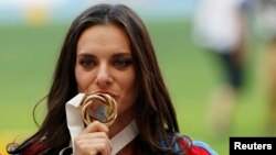 Russia's Yelena Isinbayeva kisses her gold medal at the women's pole-vault victory ceremony during the IAAF World Athletics Championships in Moscow on August 15.