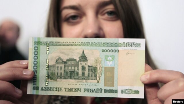 A woman holds a new 200,000 Belarusian ruble note (approximately $24.48) during a presentation to the media in Minsk on March 12.