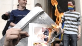 Un protestatar dînd foc unui ziar cu portretul lui Vladimir Voronin în apropierea Parlamentului