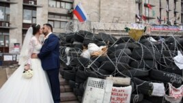 Донецк қаласының орталығында баррикада жанында сүйісіп тұрған жас жұбайлар. 2 мамыр 2014 жыл.