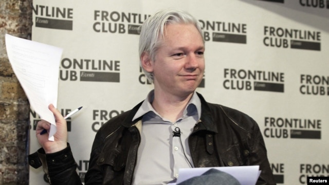 WikiLeaks founder Julian Assange holds a leaked Stratfor document at a news conference in London on February 27.