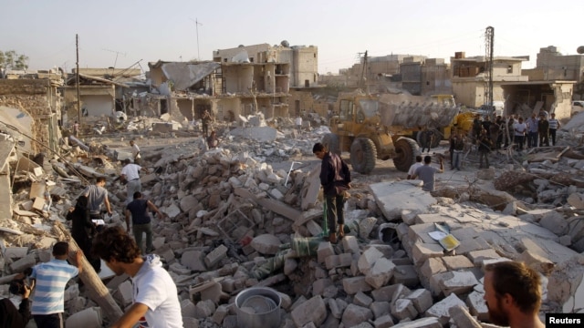 Men search for bodies of people after a Syrian air strike on Azaz.