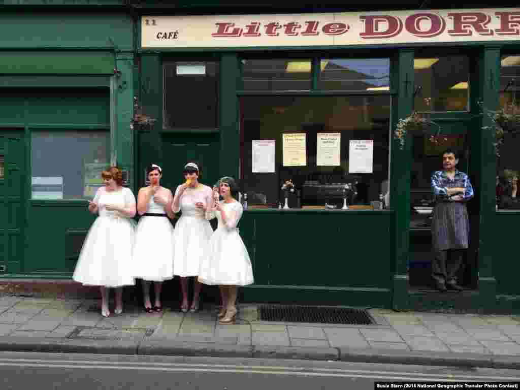 "Ladies in Waiting" by Susie Stern. Borough Market, London, United Kingdom. "While exploring Borough Market in London, I was delighted to come across four lovely young women dressed in vintage white dresses, eating ice cream as the local shopkeeper looked on. Are they brides? Or bridesmaids. I don't know, but they are obviously enjoying a very special day." 