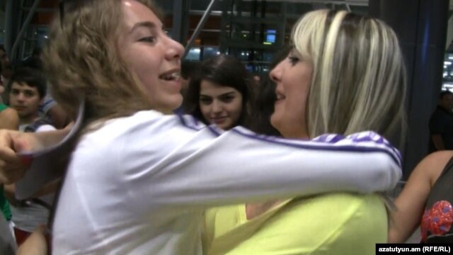 Armenia - A newly arrived Syrian Armenian woman (L) is greeted by a relative at Yerevan's Zvartnots airport, 30Jul2012.