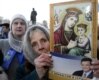 An elderly woman in the heart of the Donbas, Donestsk, holds a flyer for Viktor Yanukovych that reads "With the Donbass in my heart!" (AFP)