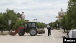 Вооруженный сотрудник спецслужб стоит на улице в Актобе. 10 июня 2016 года.
