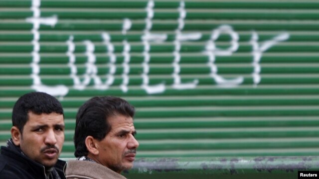Pristalice egipatske opozicije kod grafita ispisanog na Tahrir trgu u Kairu, februar 2011. 