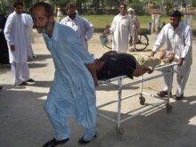 Pakistan -- Volunteers move an injured policeman into the hospital after a suicide attack near a police checkpost on the outskirts of Bannu, 06May2008