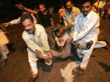 Pakistan - A Pakistani youth wounded in a bomb blast is carried away in Karachi, 18Oct2007