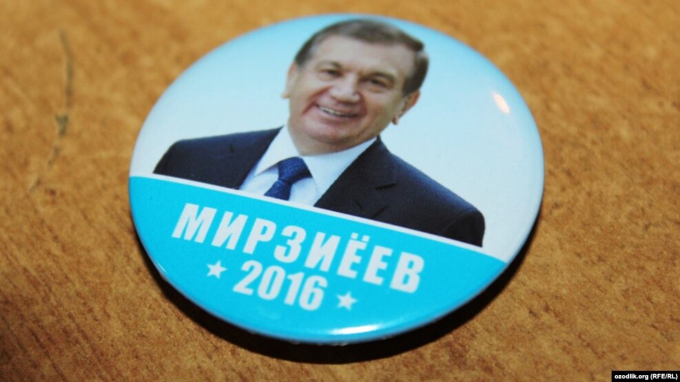 A campaign button for acting President Shavkat Mirziyaev