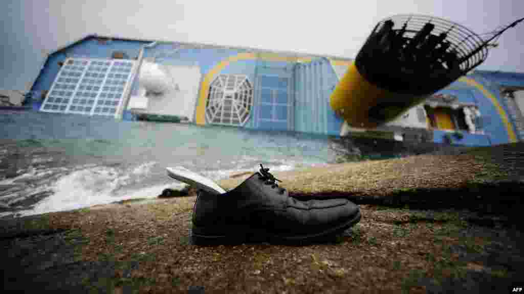 The partially submerged "Costa Concordia" cruise ship lies in the harbor of the Isola del Giglio in Italy on January 16 after it ran aground and keeled over on January 13. (AFP/Filippo Monteforte)