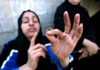 A mother shows the wedding ring of her son, Al'a Sabah, who was killed in a mortar attack days before his planned marriage (AFP)