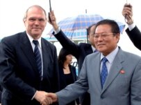 Hill (left) greeted on arrival in Pyongyang by North Korean Foreign Ministry official Ri Gun (epa)