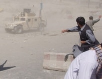 Afghans throwing stones at a U.S. military vehicle during riots in Kabul on May 29 (epa)