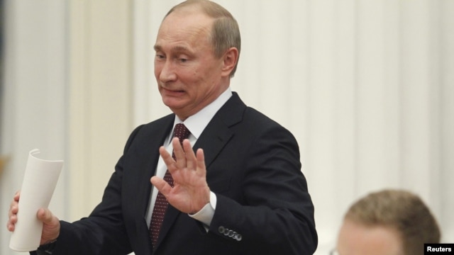 Russian President Vladimir Putin gestures as he arrives for a meeting with G20 summit participants in the Kremlin on February 15.