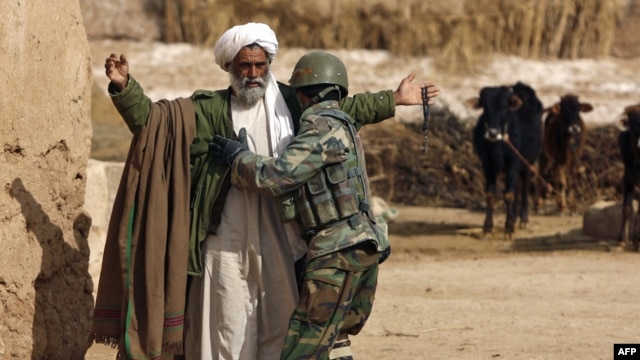 An Afghan soldier frisks a farmer during a patrol near Marjah. Can the Afghan government and its NATO allies win public support there?