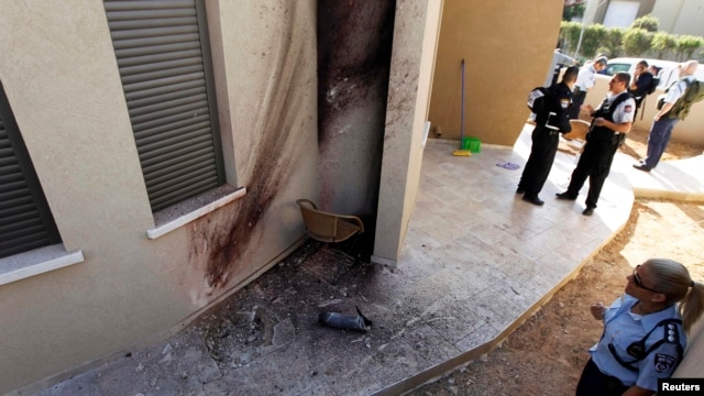 A policewoman looks at the damage after a rocket fired by Palestinian militants in Gaza landed in the southern town of Sderot on March 21.